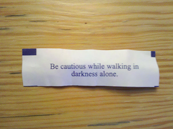 Fortune cookie paper with a sassy saying: "Be cautious while walking in darkness alone."