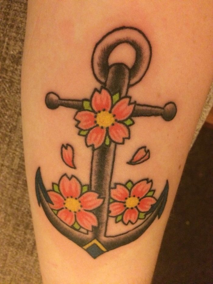 Anchor tattoo with pink flowers on skin, showcasing personal tattoo stories.