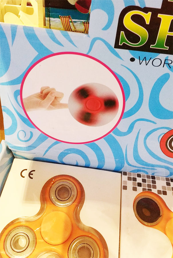 Fidget spinner with an image showing a finger spinning it, highlighting a Photoshop fail on the toy packaging.