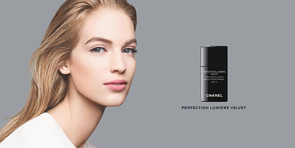 Young woman with flawless skin posing next to a Chanel Perfection Lumière Velvet cosmetic bottle, showing Photoshop fail contrast.