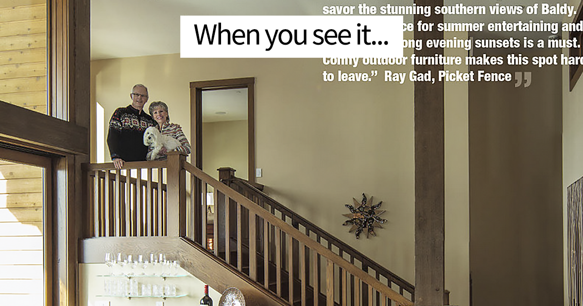 Couple standing on wooden staircase with a small dog and a Photoshop fail involving duplicated staircase railings.