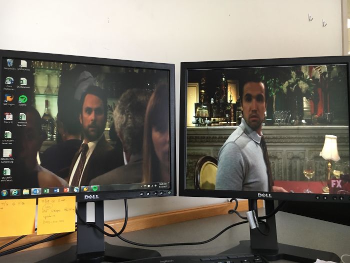 Two desktop monitors display a hilariously genius wallpaper scene that aligns seamlessly for a comedic effect.