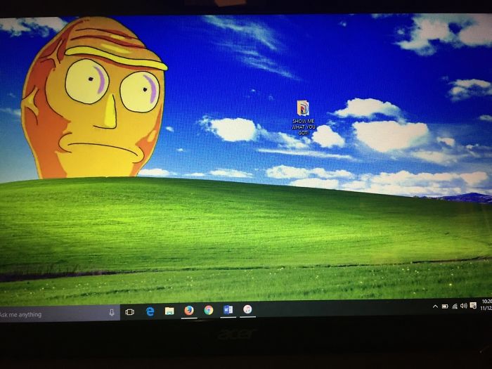 Creative desktop wallpaper featuring a cartoon face on a grassy hill with a single desktop icon labeled "SHOW ME WHAT YOU GOT."