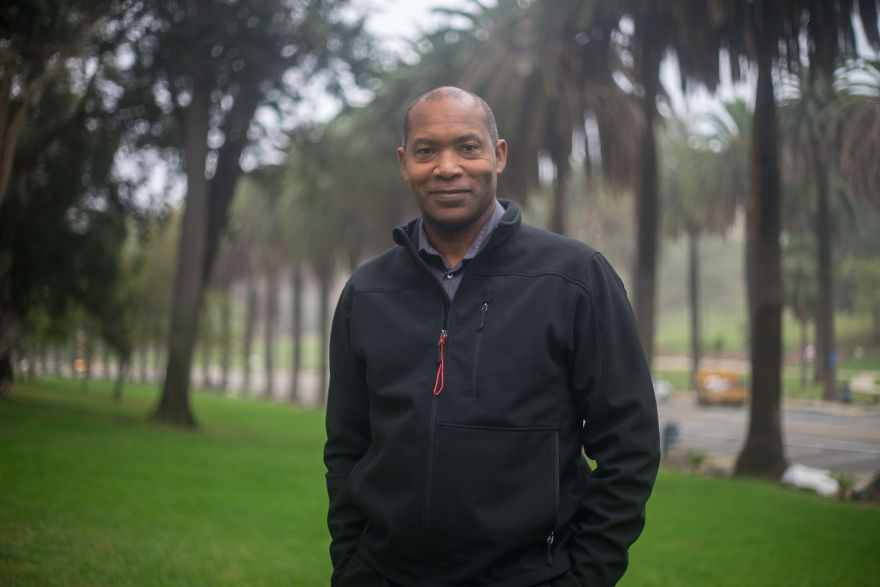 Man standing outdoors on a grassy path lined with tall trees, part of interviewing 35 people on their birthdays project.