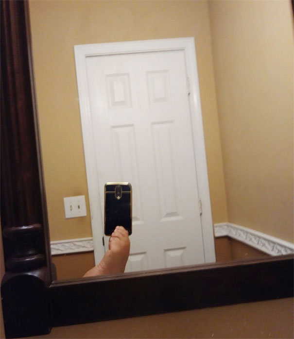 Person taking a selfie in a mirror, capturing their foot in a humorous attempt to sell the mirror online.