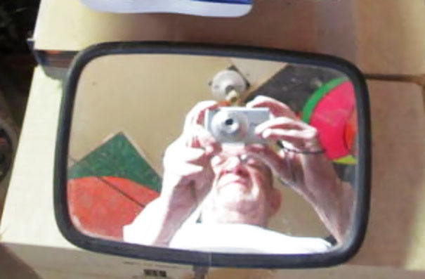 Person taking a photo of themselves in a mirror, capturing a colorful background.