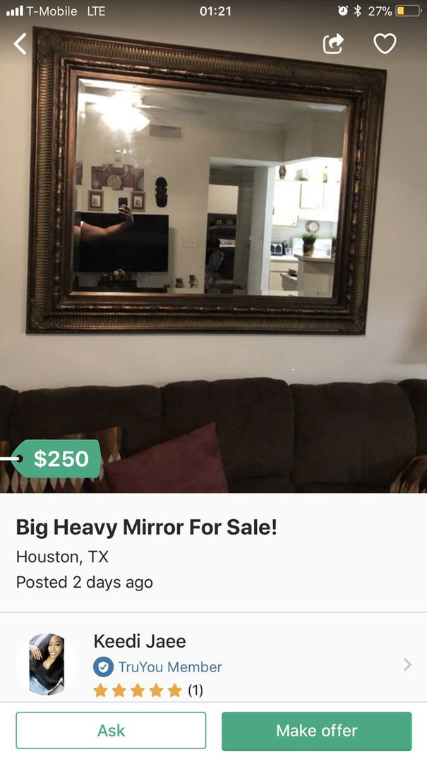 Large ornate mirror for sale, reflecting a living room and kitchen scene in a cozy home setting.