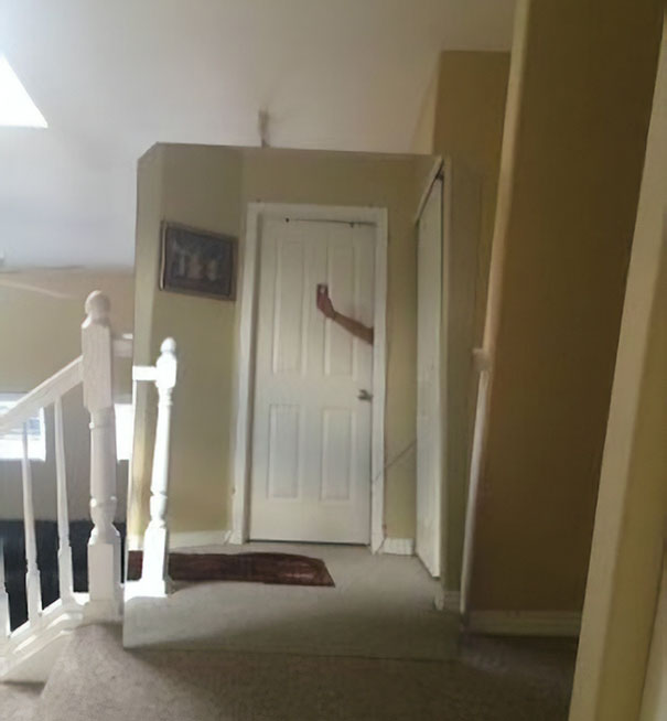 A mirror reflecting part of an arm in a hallway, illustrating a humorous attempt to sell mirrors.