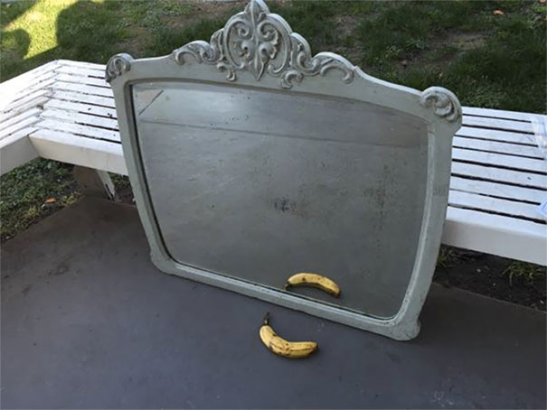Intricately designed mirror with a banana on a bench, highlighting unique mirror selling perspectives.