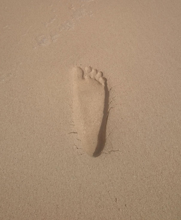 Foot Print In Sand Forms An Optical Illusion
