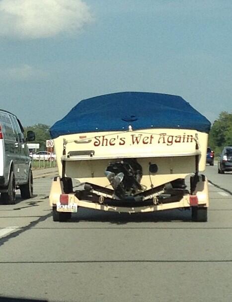 Funny named white boat being pulled in a trailer