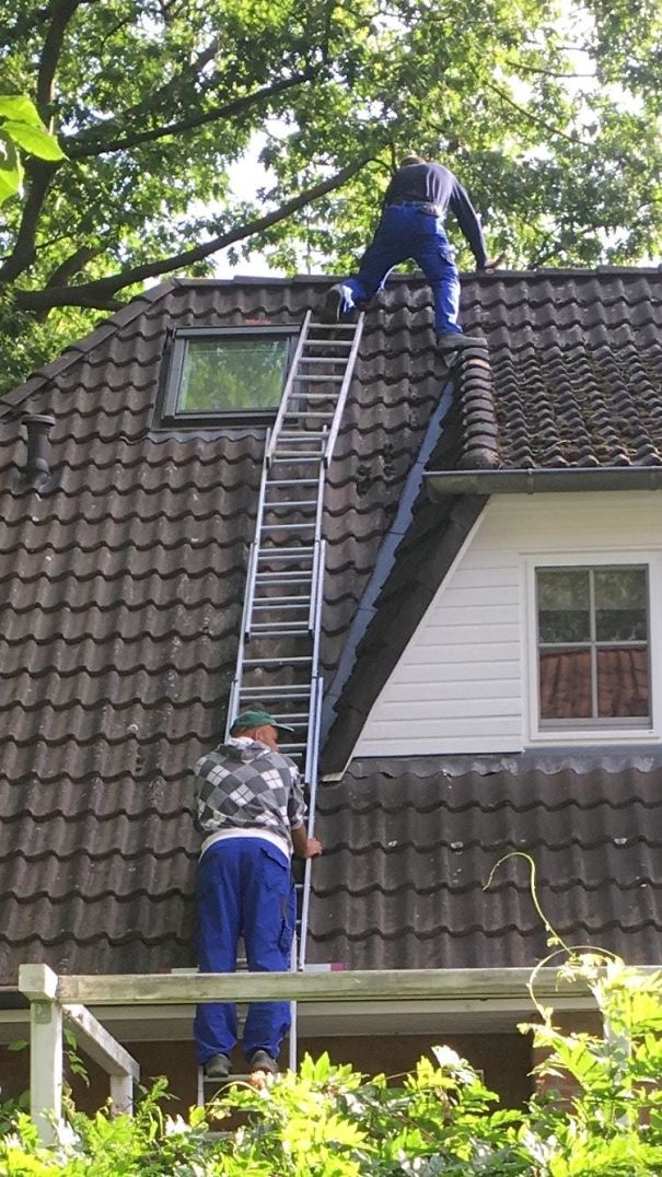 Standing On A Ladder That Is Held By A Ladder That Placed In A Gutter And Is Held By A Guy Who Is Standing On A Ladder