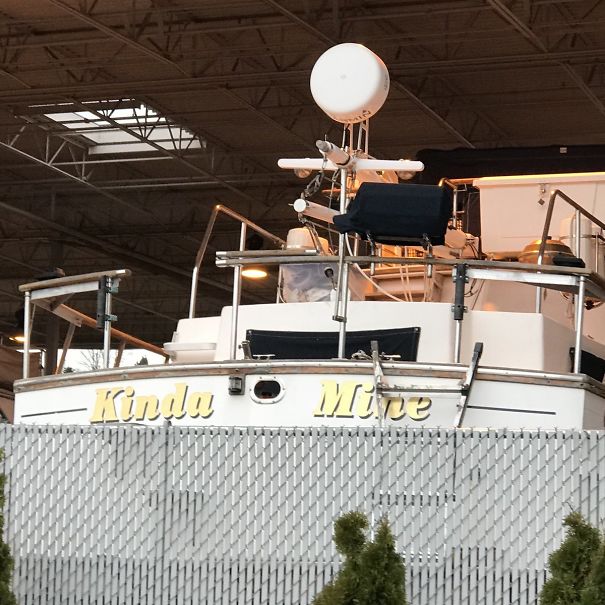 Funny named white boat behind the fence 