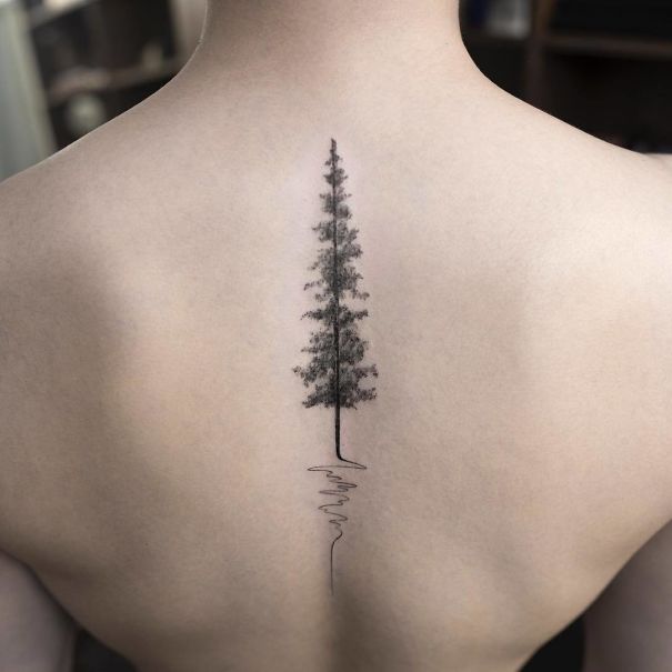 Minimalist spine tattoo of a pine tree down the back, showcasing unique tattoo ideas.