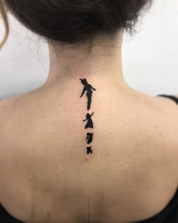 Minimalist spine tattoo with silhouetted figures, showcasing one of the best tattoo ideas for a unique style statement.