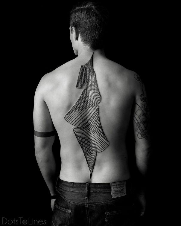 Geometric spine tattoo design on a person's back, featuring intricate black lines.