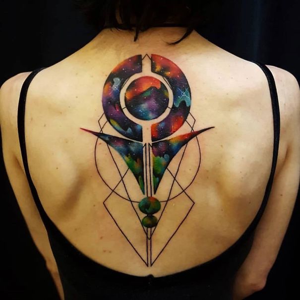 A colorful, geometric spine tattoo design featuring cosmic elements on the back.