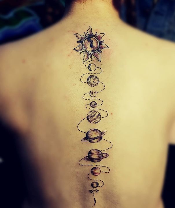 Spine tattoo with solar system design, featuring planets and sun along the backbone.