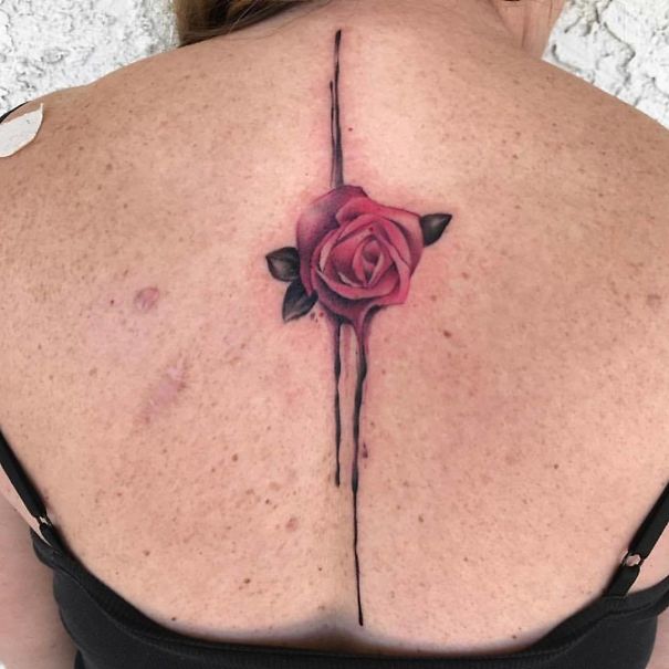 Rose spine tattoo design on woman's back, showcasing one of the best spine tattoo ideas.