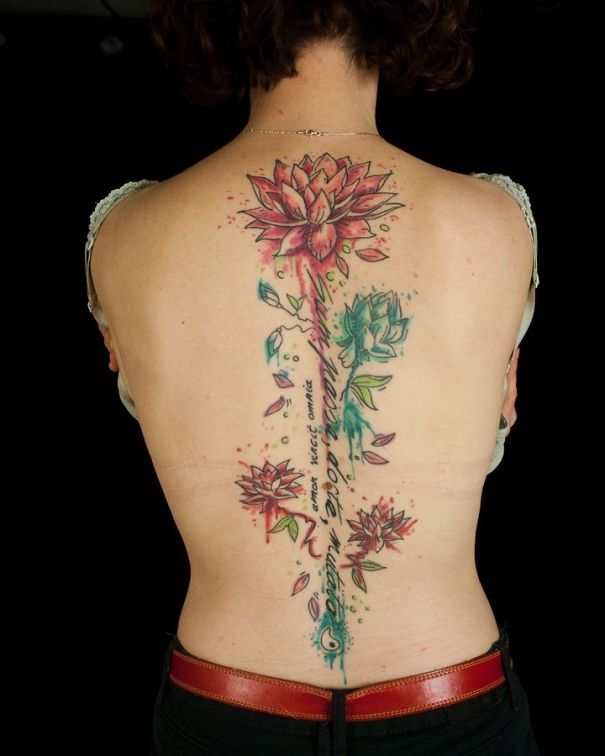 Colorful lotus spine tattoo design on woman's back.