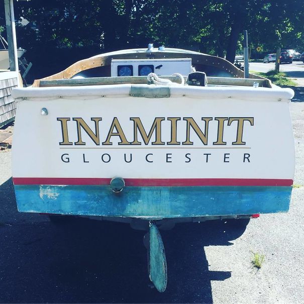 Funny named white boat parked in a parking lot 