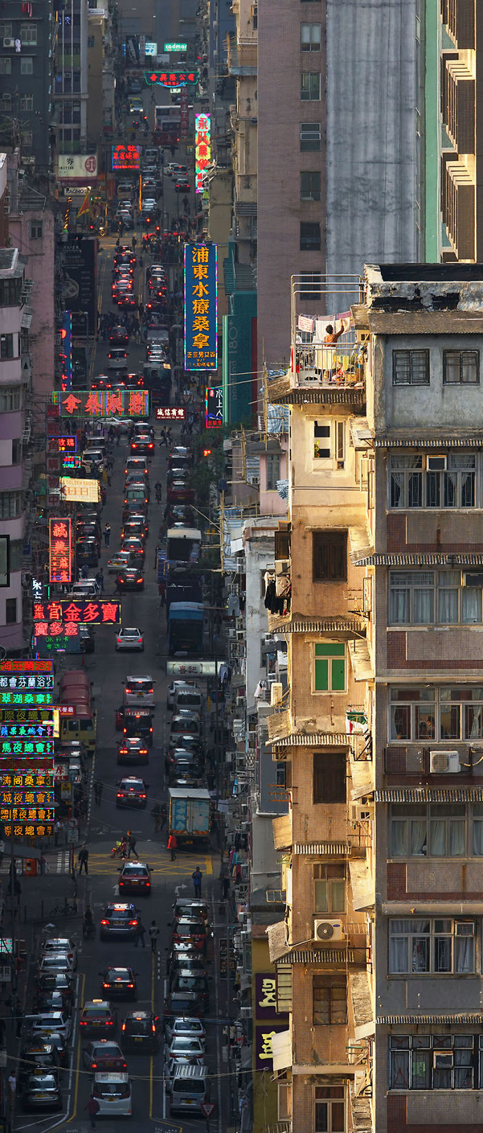 "Concrete Canyon," A Lady Is Collecting Her Laundry At Sunset Above The Bustle Of The Street