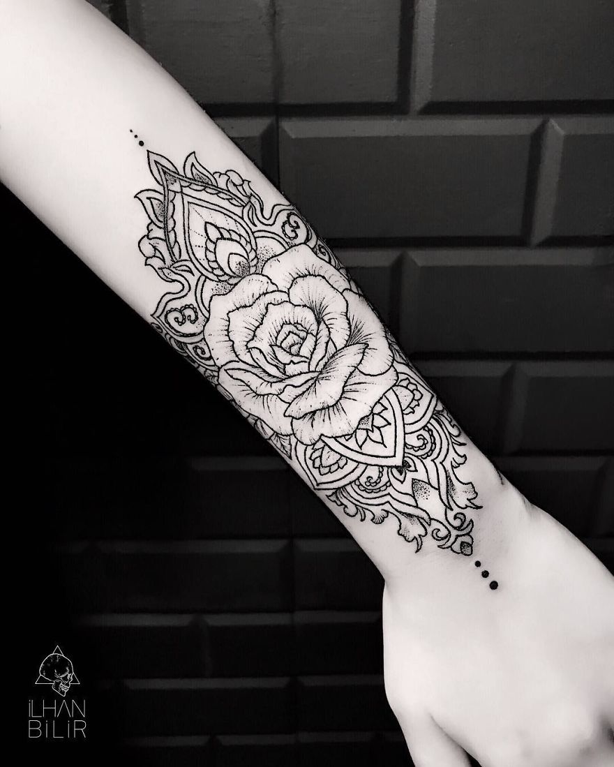 Tattoo by Ilhan Bilir showcasing simplicity and contrast with dotwork on forearm, featuring floral and geometric designs.
