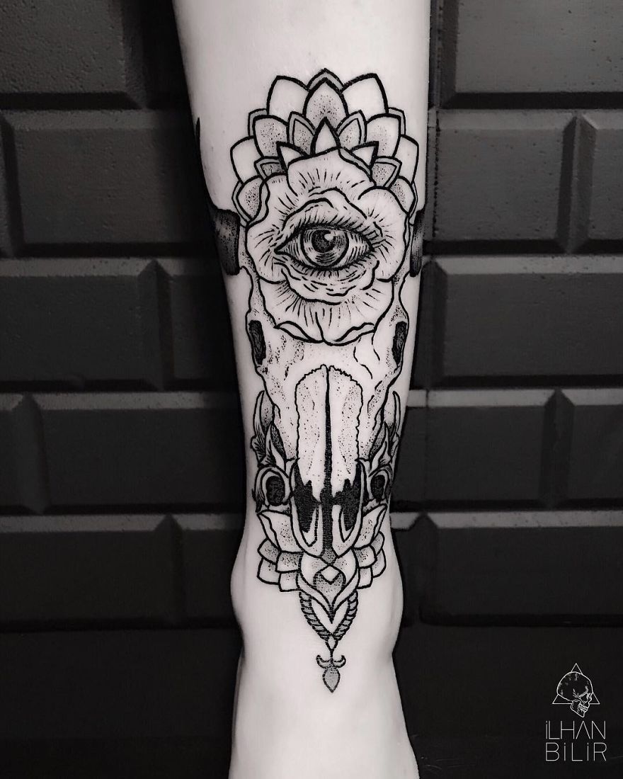 Tattoo featuring dotwork and contrast by artist Ilhan Bilir, depicting an eye within a decorative skull design.