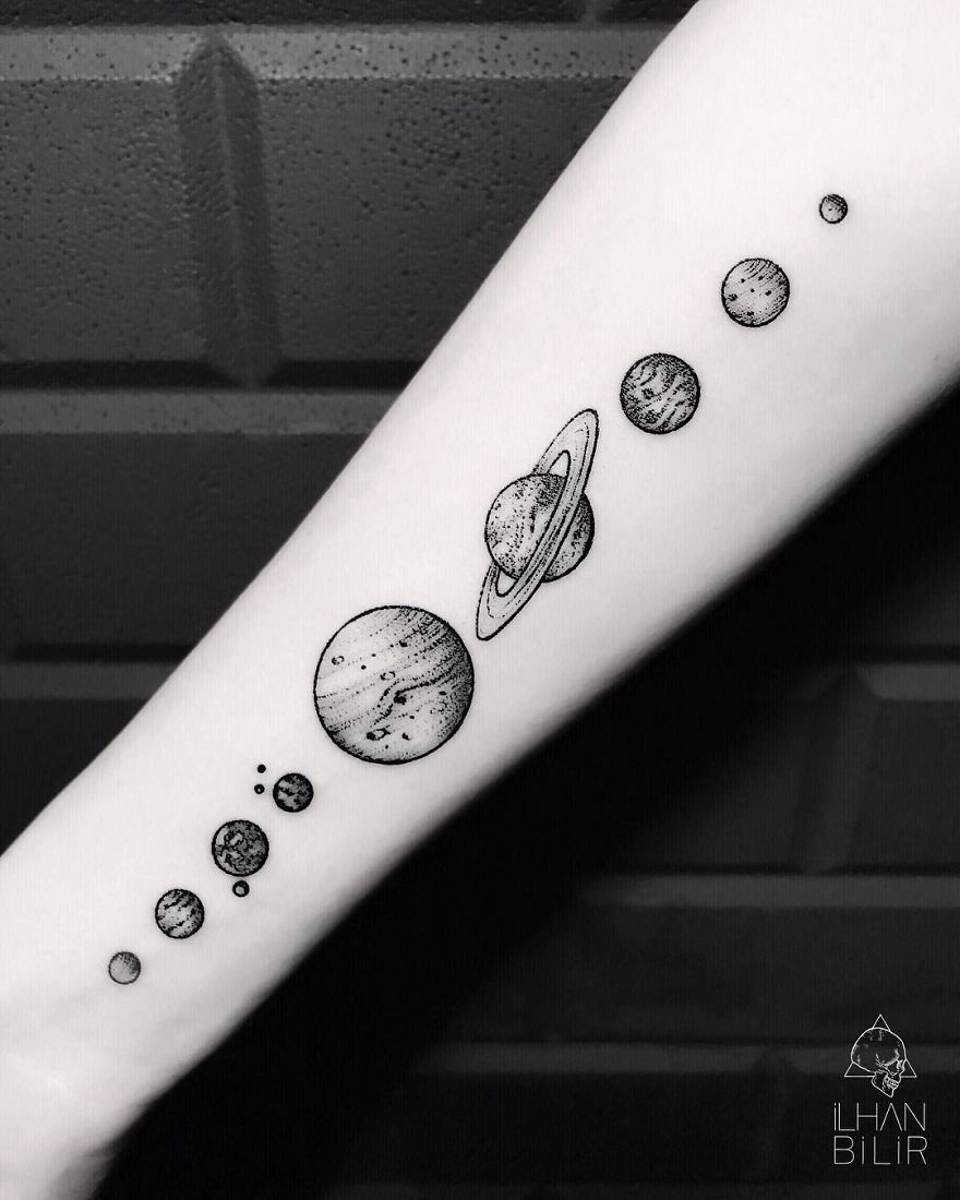Tattoo of planetary alignment on forearm, showcasing simplicity, contrast, and dotwork by artist Ilhan Bilir.