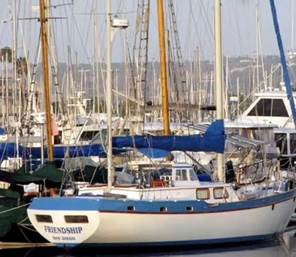 Funny named white and blue boat docked 