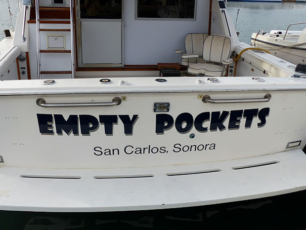 Funny named white boat docked 