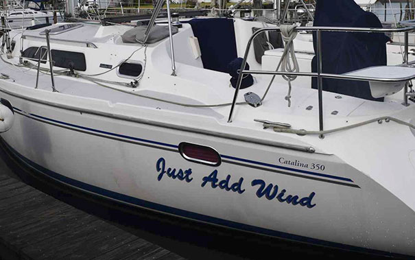 Funny named white boat docked 