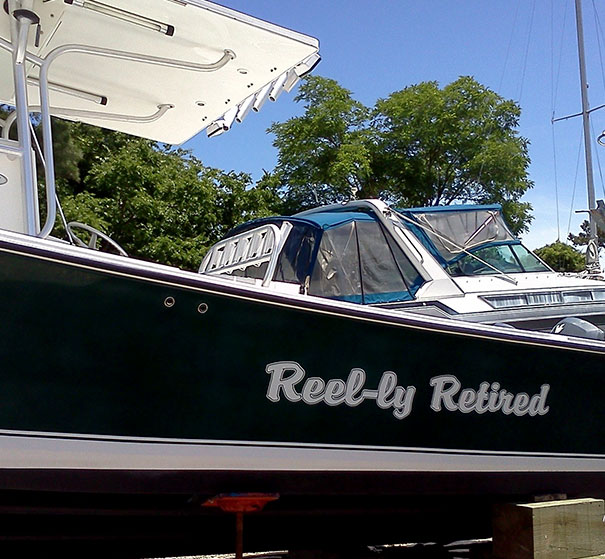 Funny named white and black colored boat docked 