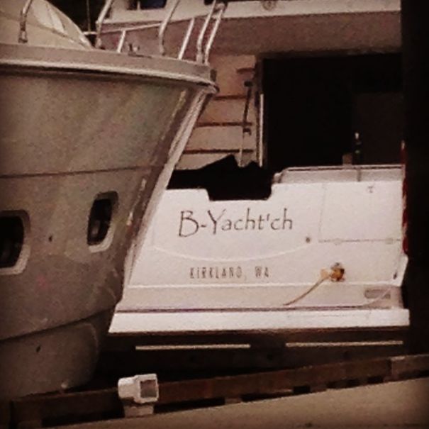 Funny named white boat near a yacht 