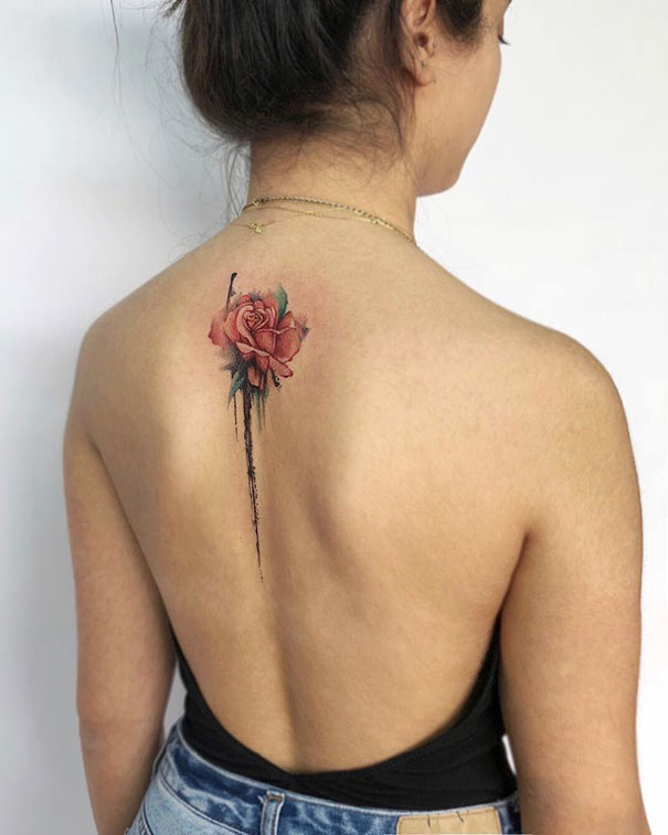 Rose spine tattoo design on a woman's back, featuring delicate lines and vibrant colors.