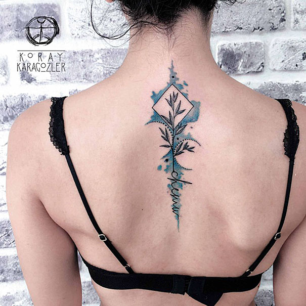 Woman with intricate spine tattoo featuring abstract design and blue accents.