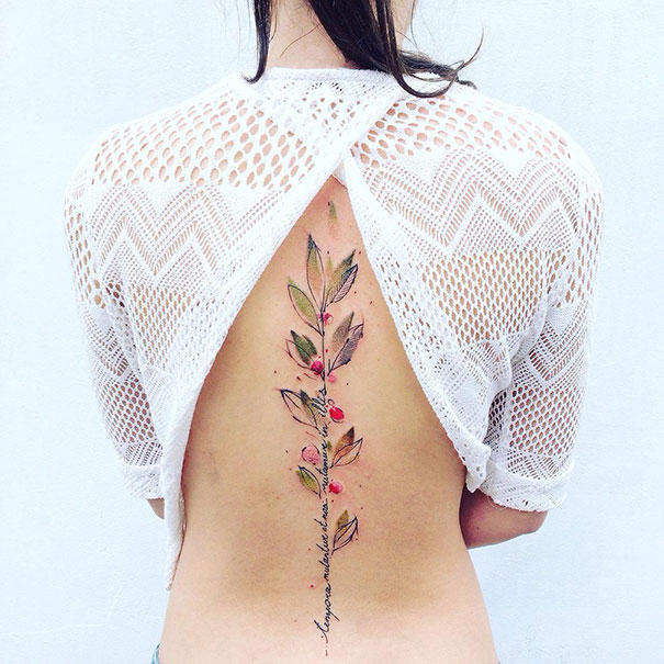 Floral spine tattoo featured on an open-back white crochet top, highlighting one of the best spine tattoo ideas.