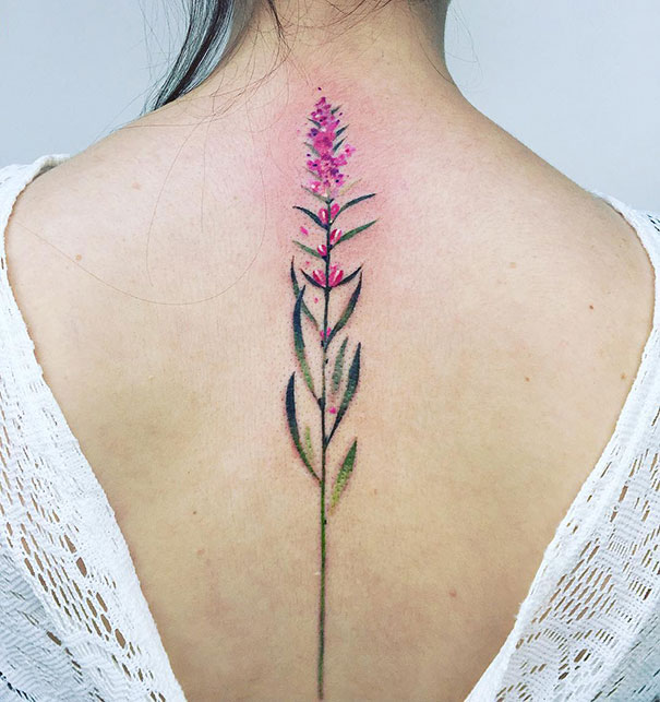 Delicate floral spine tattoo design on a person's back.