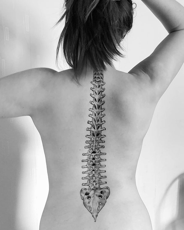 Spine tattoo idea of a detailed vertebrae design on a woman's back.