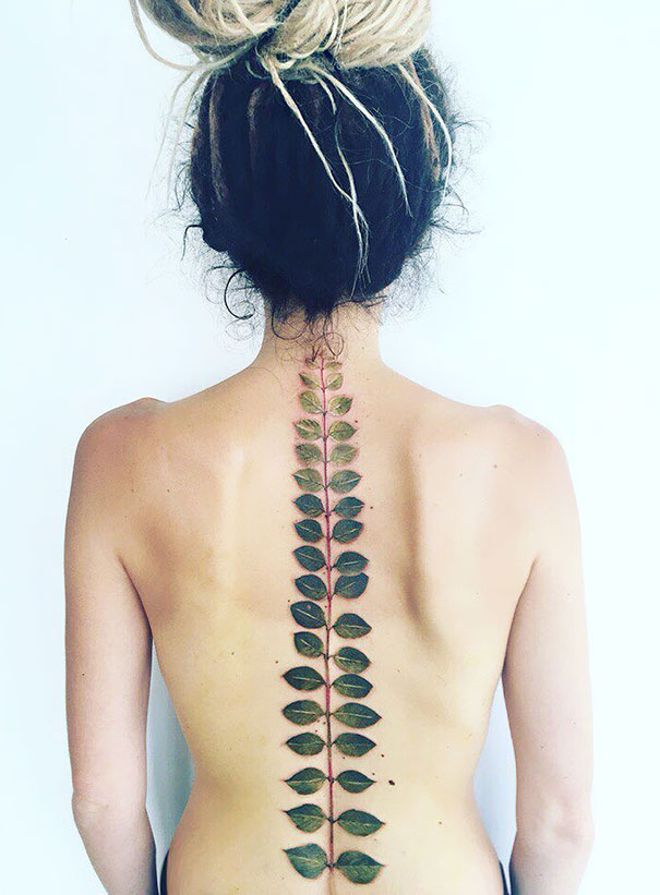 Leaf-inspired spine tattoo design on a person's back, emphasizing creative body art.