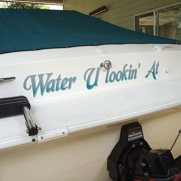 Funny named white boat with a cover on 