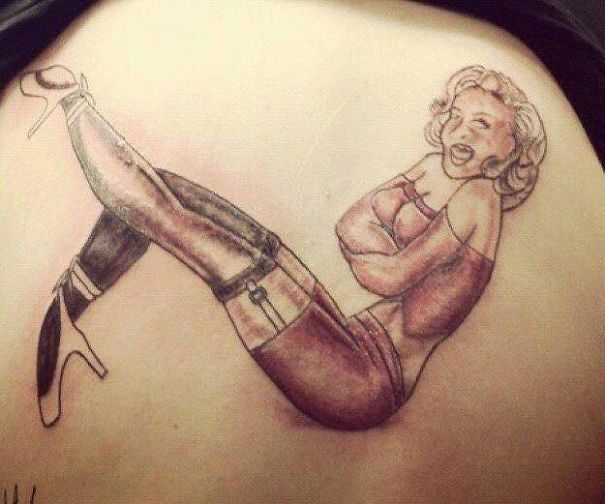 Bad tattoo fail of a woman with mismatched legs and arms, humorous and cringe-worthy design.