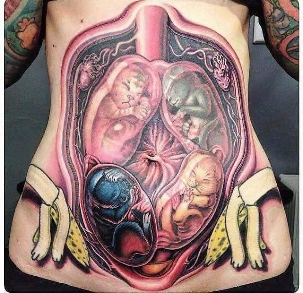Tattoo fail of kittens in a womb design on a person's stomach, highlighting bad tattoo decisions.