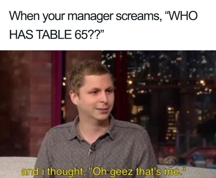 A man reacts nervously on TV after a manager yells about table 65 in a humorous restaurant meme.