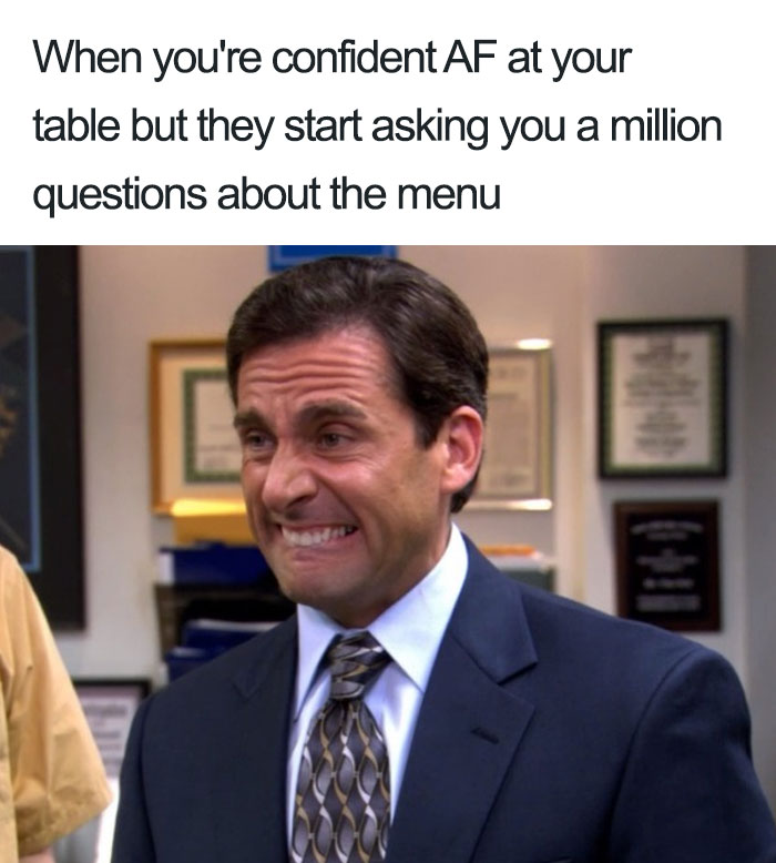 Confused man in a suit with a forced smile, captioned about struggling with menu questions at a restaurant.