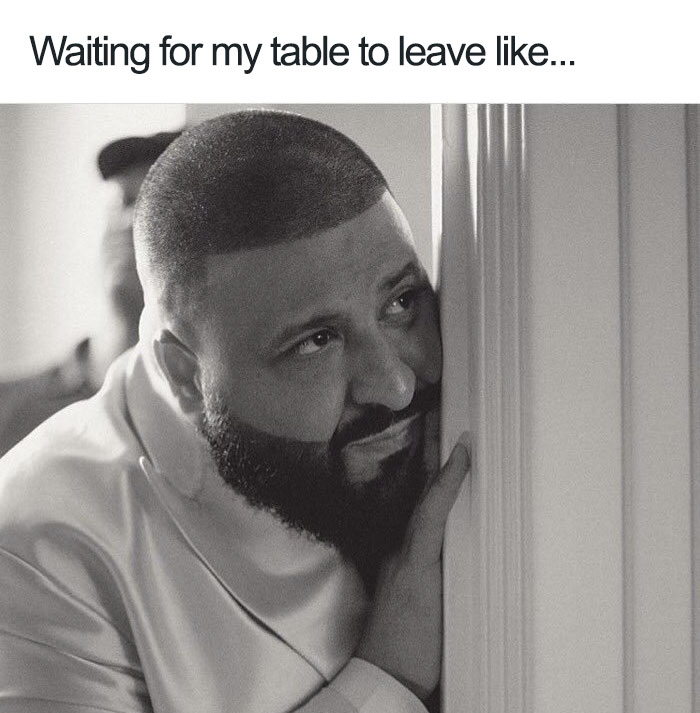 A person peeks around a corner with an expression of anticipation, capturing a relatable restaurant meme moment.