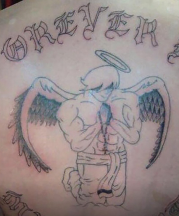 Bad tattoo fail of an angel with muscular arms, misspelled text, and uneven wings.