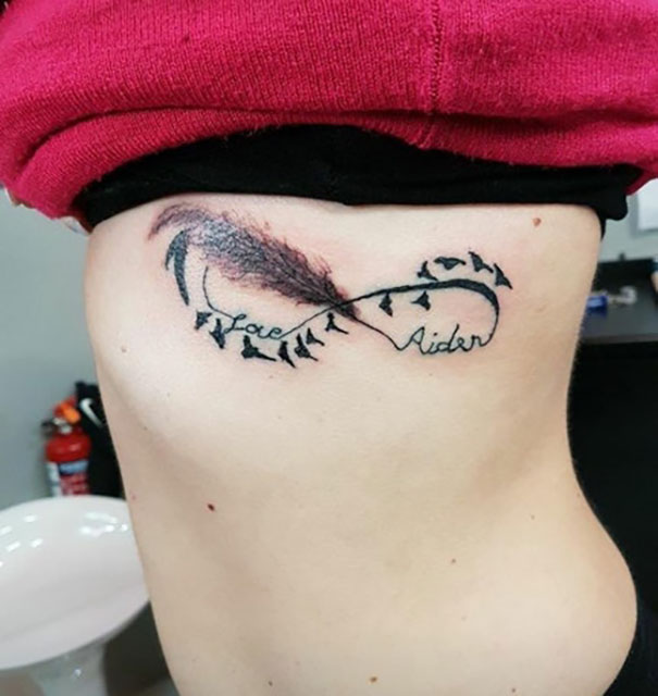 Bad tattoo fail with feather design and text on a person’s side, showcasing humorous and cringeworthy artwork.