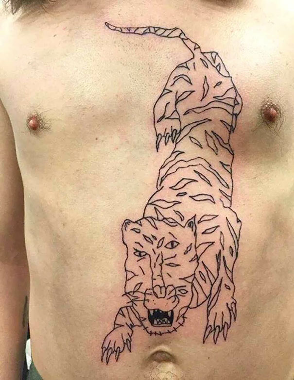 Tiger tattoo fail with awkward lines on a man's chest.