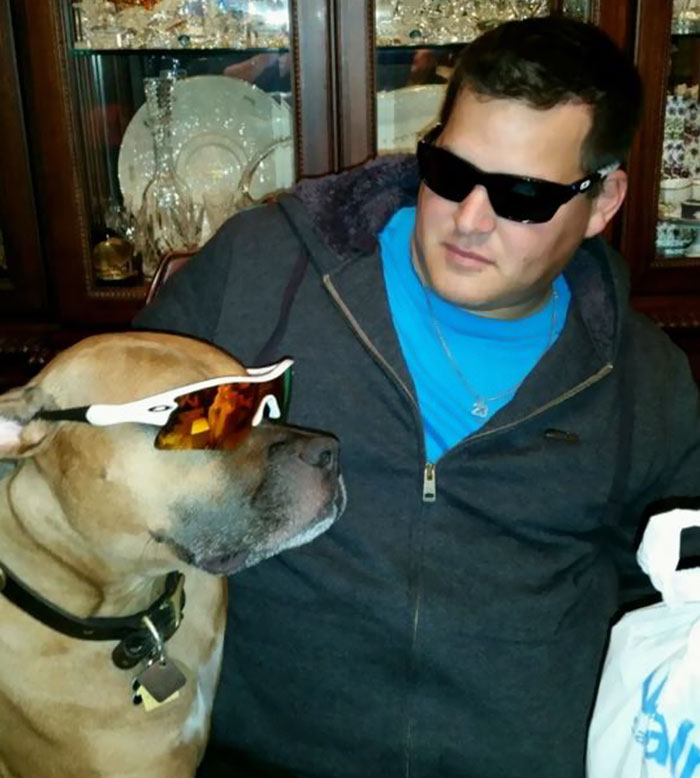 Man and rescue dog wearing sunglasses, with matching tattoo discussed. Man and rescue dog wearing sunglasses, with matching tattoo discussed.